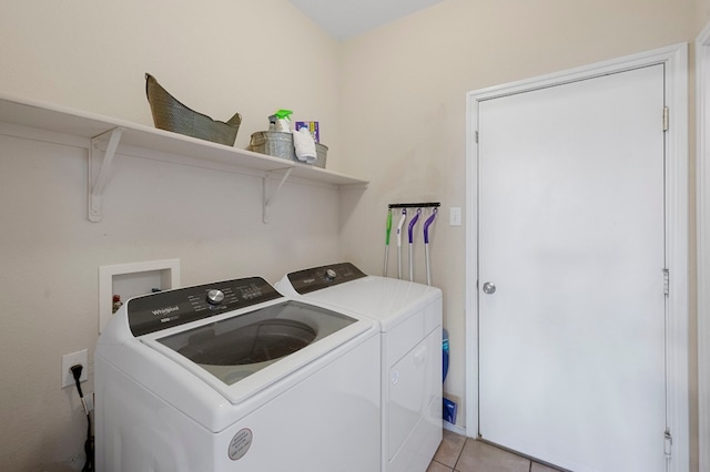 clothes washing area with washing machine and dryer and light tile patterned floors