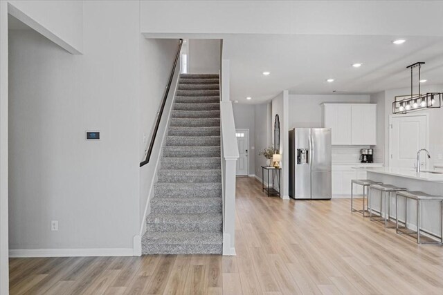 stairway featuring sink and wood-type flooring