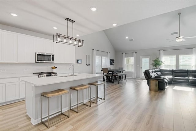 kitchen featuring a kitchen island with sink, plenty of natural light, hanging light fixtures, and sink