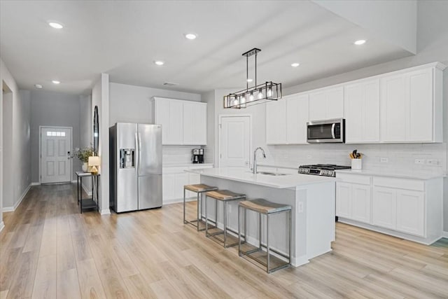 kitchen with white cabinets, light wood-type flooring, sink, and appliances with stainless steel finishes