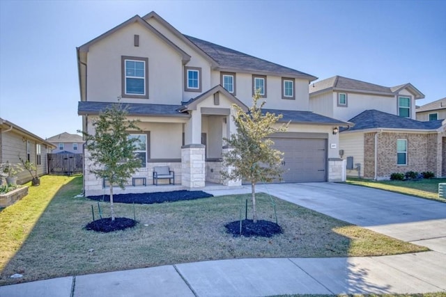 view of front of property featuring an attached garage, a front lawn, concrete driveway, and stucco siding