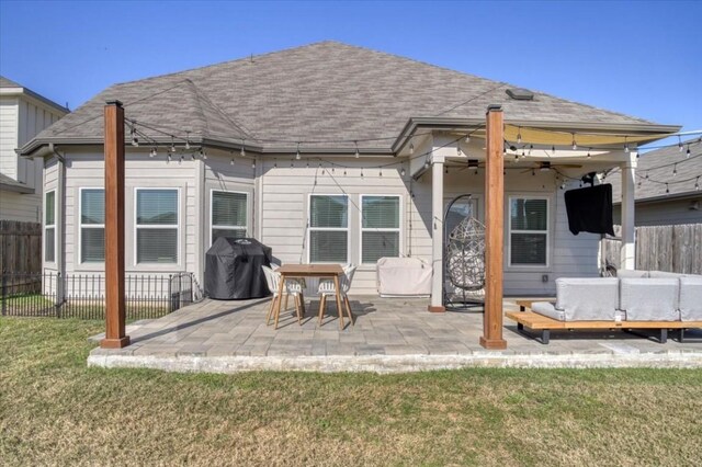 rear view of property with a lawn, ceiling fan, and a patio