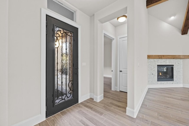 entrance foyer featuring beam ceiling and light hardwood / wood-style floors