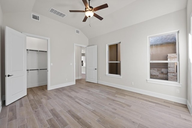 unfurnished bedroom featuring a closet, light hardwood / wood-style floors, vaulted ceiling, and ceiling fan