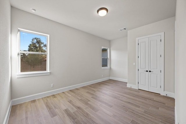 unfurnished bedroom featuring a closet and light hardwood / wood-style flooring