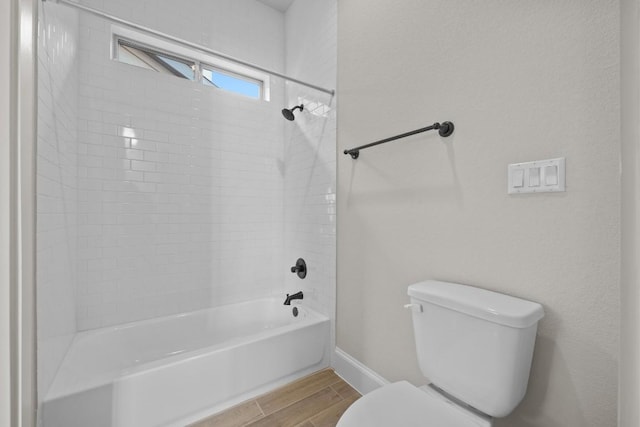 bathroom featuring tiled shower / bath combo, toilet, and wood-type flooring