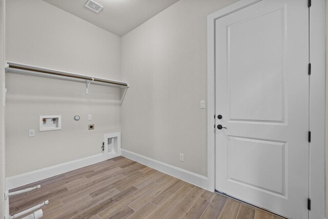 laundry area with hookup for an electric dryer, gas dryer hookup, light wood-type flooring, and washer hookup