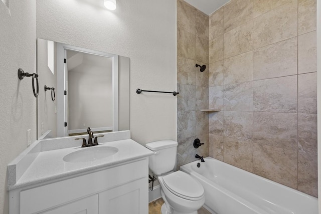 full bathroom with vanity, tiled shower / bath combo, and toilet