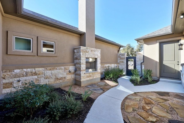 entrance to property with an outdoor stone fireplace and a patio