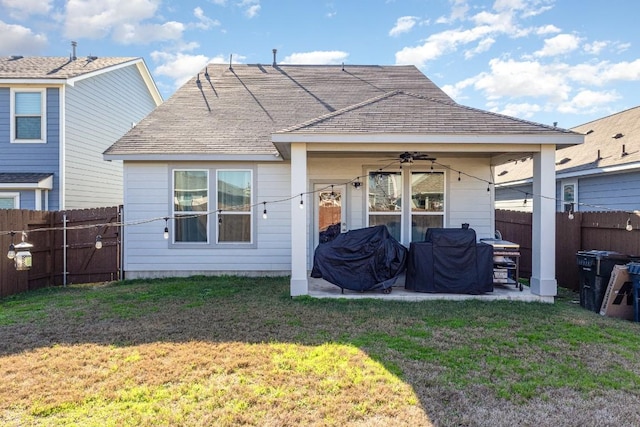 rear view of house with ceiling fan, a lawn, a patio area, and a fenced backyard