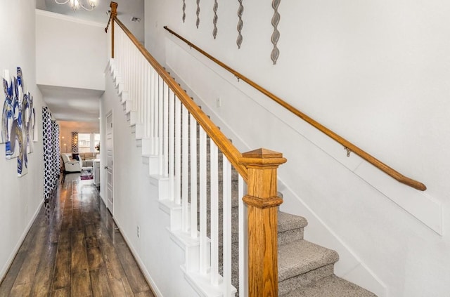 staircase featuring baseboards and wood finished floors