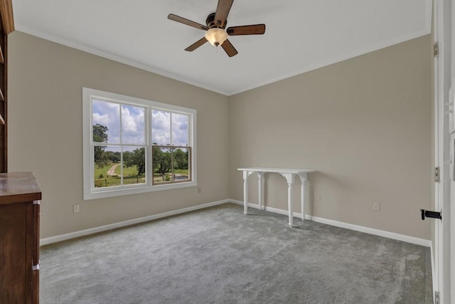 carpeted spare room with ceiling fan and crown molding