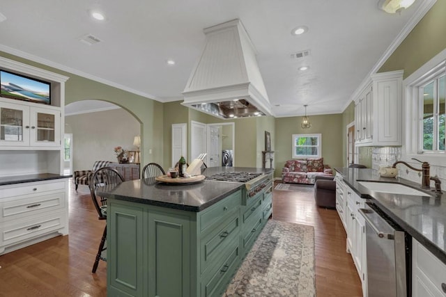 kitchen with white cabinets, green cabinetry, a kitchen island, custom range hood, and stainless steel appliances