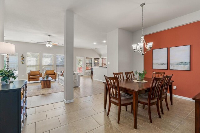 tiled dining area with ceiling fan with notable chandelier