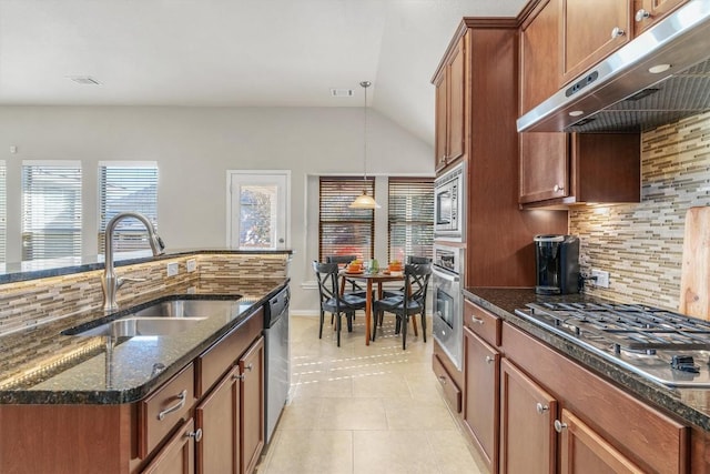 kitchen with light tile patterned floors, stainless steel appliances, tasteful backsplash, and dark stone counters