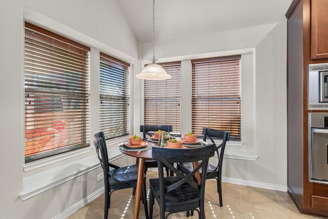 tiled dining space featuring lofted ceiling