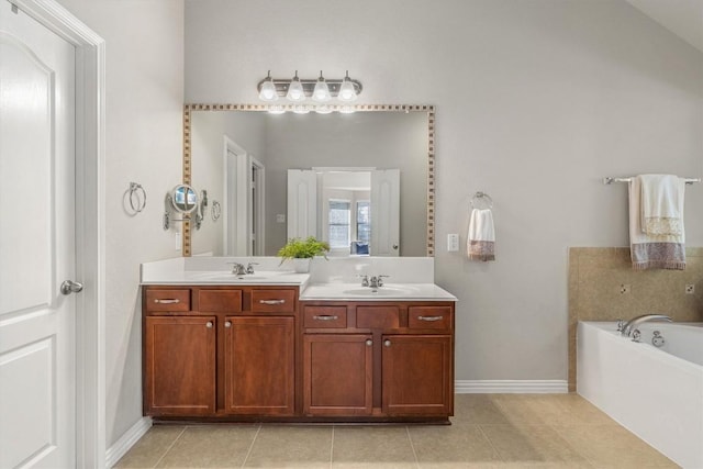 bathroom featuring tile patterned floors, a washtub, and vanity