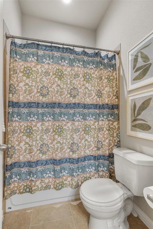 bathroom featuring toilet and shower / tub combo with curtain