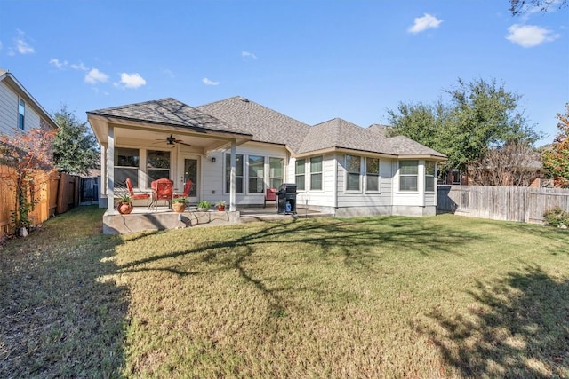 back of property with a patio area, ceiling fan, and a yard