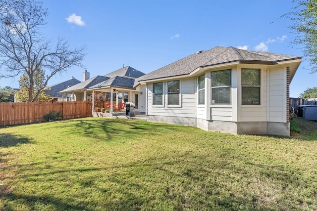 back of house with a patio area and a yard