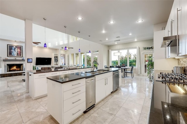 7302 Matisse Pointe Dr, Jonestown, TX 78645 - kitchen featuring a sink, a large island, stainless steel dishwasher, open floor plan, and a warm lit fireplace