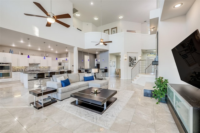 living room featuring a towering ceiling and ceiling fan