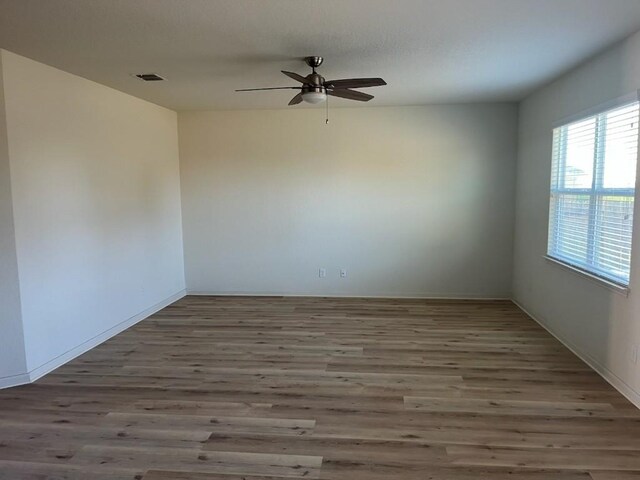 empty room with ceiling fan and dark hardwood / wood-style floors