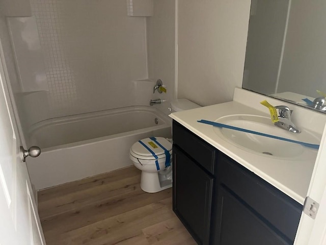 full bathroom with hardwood / wood-style floors, vanity, bathing tub / shower combination, and toilet