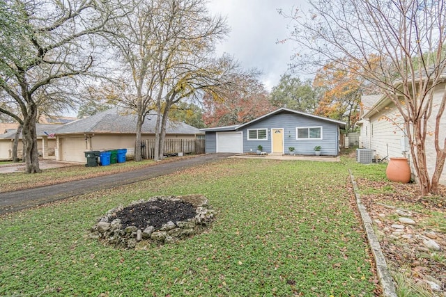 view of front of home with central AC, a front yard, and a garage