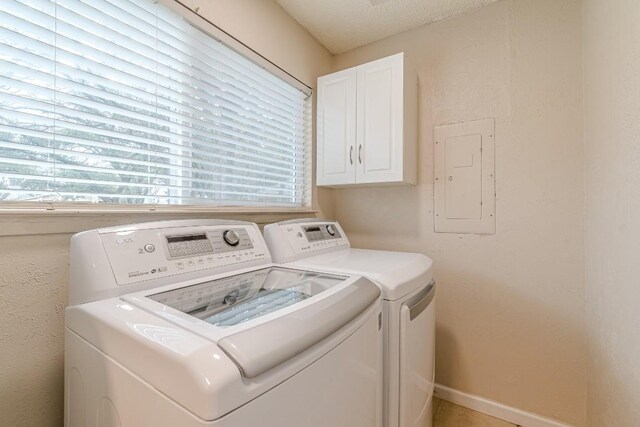 laundry room with cabinets, independent washer and dryer, electric panel, and a wealth of natural light