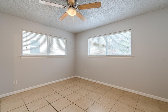 tiled empty room with ceiling fan and a textured ceiling