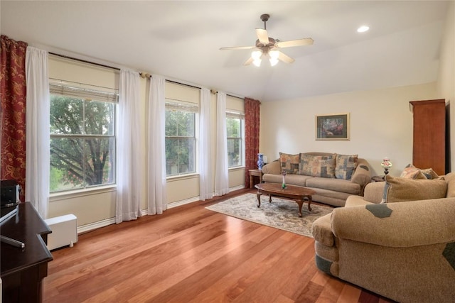 living room featuring lofted ceiling, light hardwood / wood-style floors, ceiling fan, and a healthy amount of sunlight