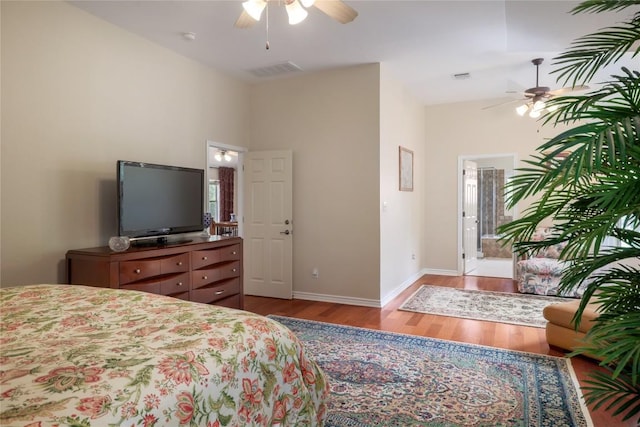 bedroom featuring ensuite bathroom, ceiling fan, light hardwood / wood-style floors, and lofted ceiling