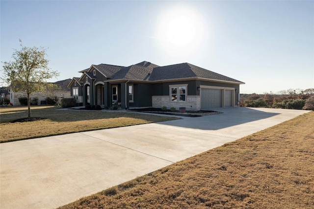view of front of home with stone siding, a front yard, concrete driveway, and an attached garage