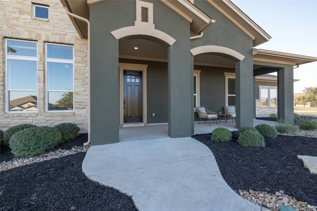 view of exterior entry featuring a patio area