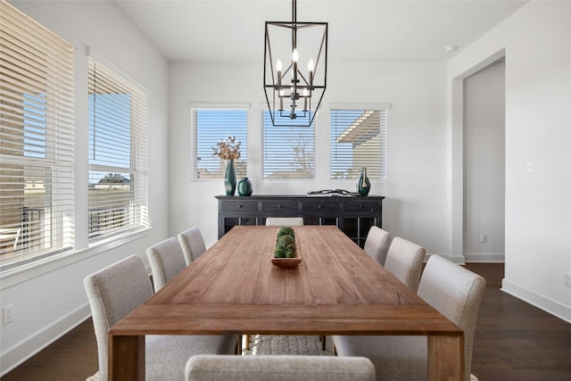 dining space with dark hardwood / wood-style floors and a notable chandelier