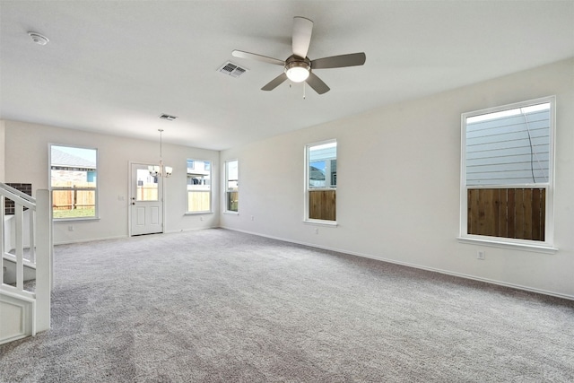 unfurnished living room with carpet and ceiling fan with notable chandelier