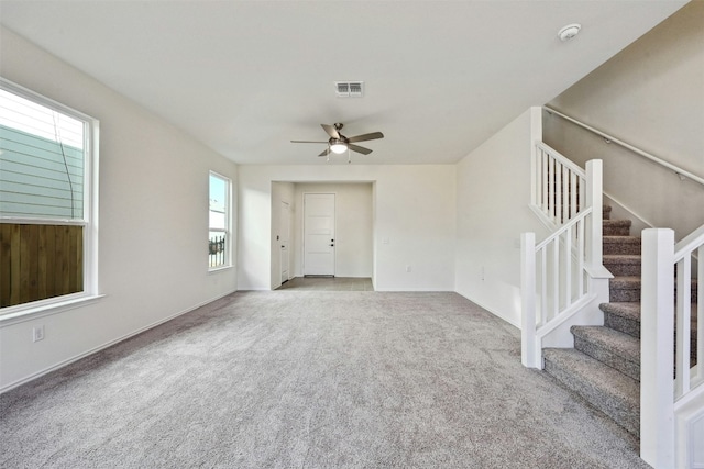 unfurnished living room featuring ceiling fan and light carpet