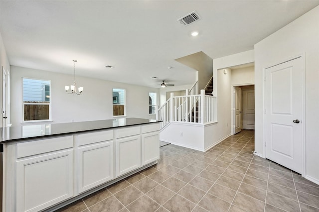 kitchen featuring decorative light fixtures, white cabinetry, and ceiling fan with notable chandelier