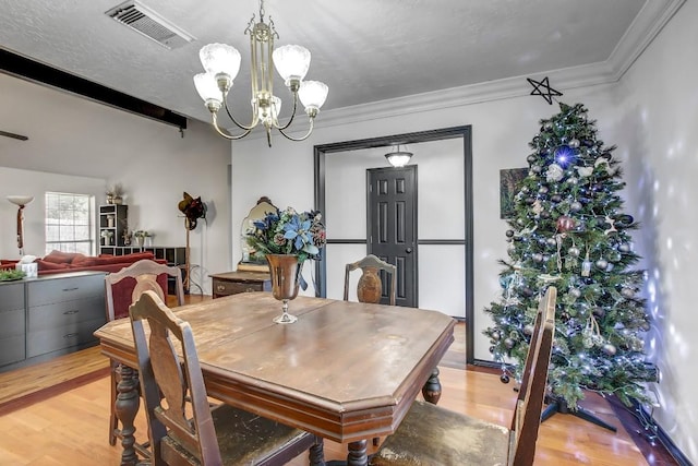 dining room featuring beam ceiling, light hardwood / wood-style floors, ornamental molding, and a notable chandelier