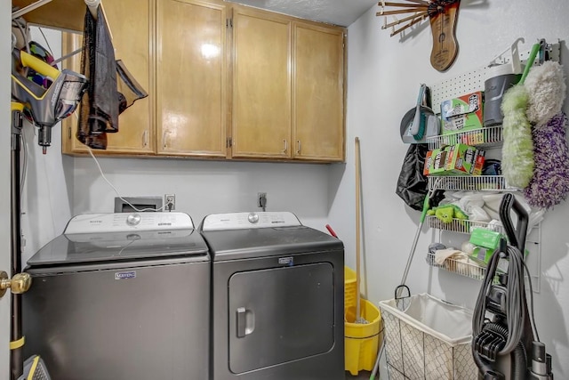 laundry room with washer and clothes dryer and cabinets