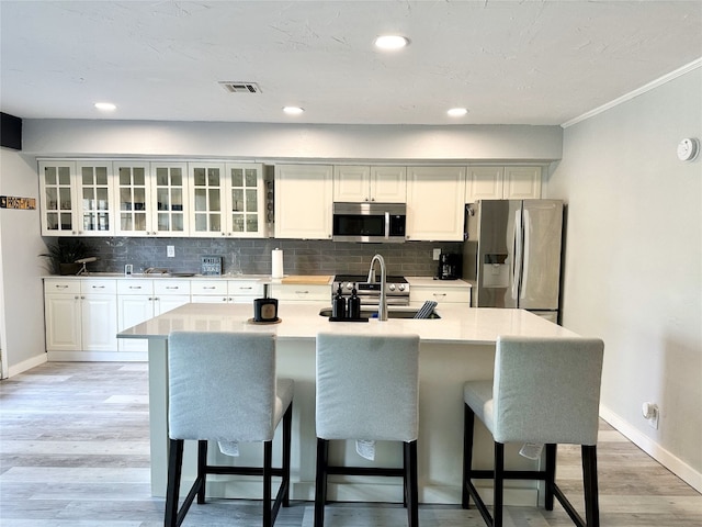 kitchen featuring white cabinets, appliances with stainless steel finishes, light hardwood / wood-style floors, and sink