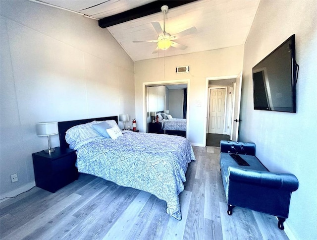 bedroom featuring hardwood / wood-style floors, vaulted ceiling with beams, and ceiling fan