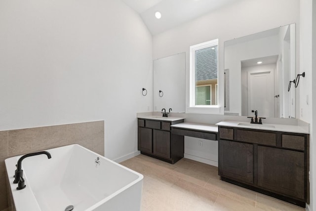 208 San Xavier St, Georgetown, TX 78633 - full bath featuring a freestanding bath, vanity, vaulted ceiling, tile patterned floors, and recessed lighting