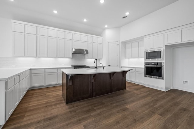208 San Xavier St, Georgetown, TX 78633 - kitchen featuring stainless steel appliances, tasteful backsplash, an island with sink, dark wood-type flooring, and recessed lighting