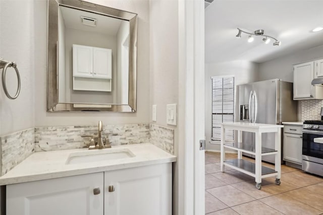 bathroom featuring decorative backsplash, vanity, and tile patterned floors