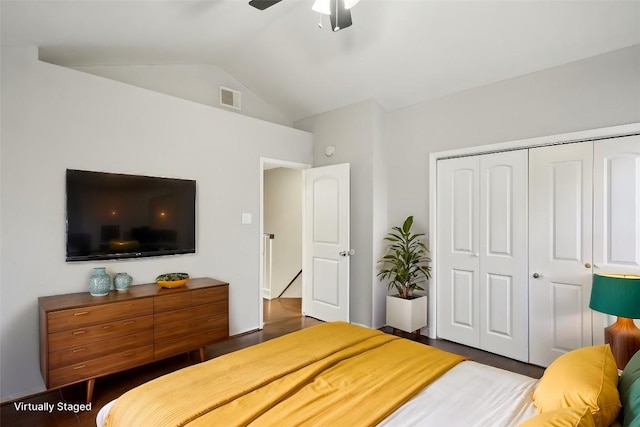 bedroom with dark hardwood / wood-style floors, a closet, lofted ceiling, and ceiling fan