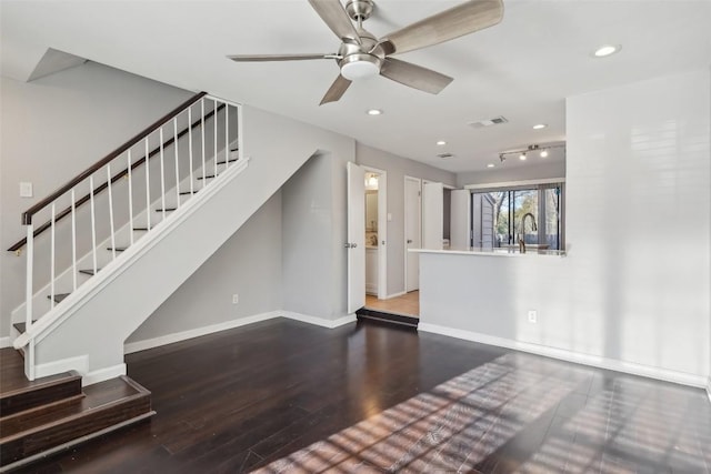 unfurnished living room featuring hardwood / wood-style flooring, ceiling fan, and sink