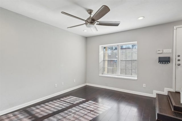 empty room with ceiling fan and dark hardwood / wood-style flooring