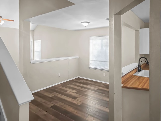 unfurnished dining area with ceiling fan, dark wood-type flooring, and sink